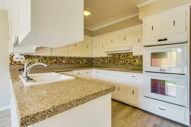 kitchen featuring sink, backsplash, white double oven, and kitchen peninsula