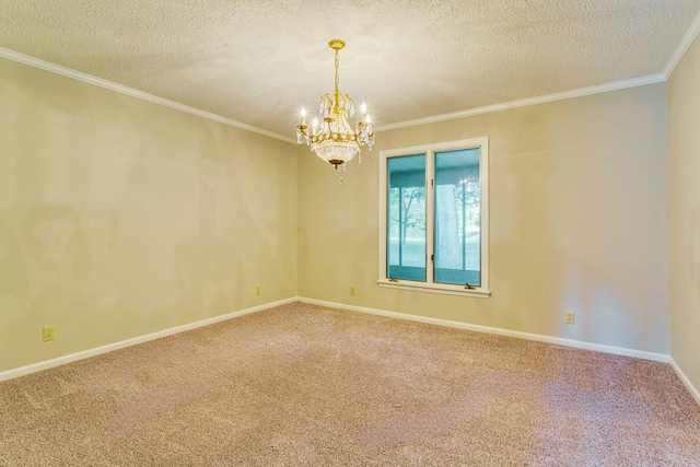 spare room featuring a textured ceiling, carpet floors, ornamental molding, and a chandelier