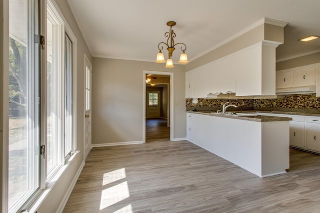 kitchen with white cabinetry, kitchen peninsula, light hardwood / wood-style floors, and hanging light fixtures