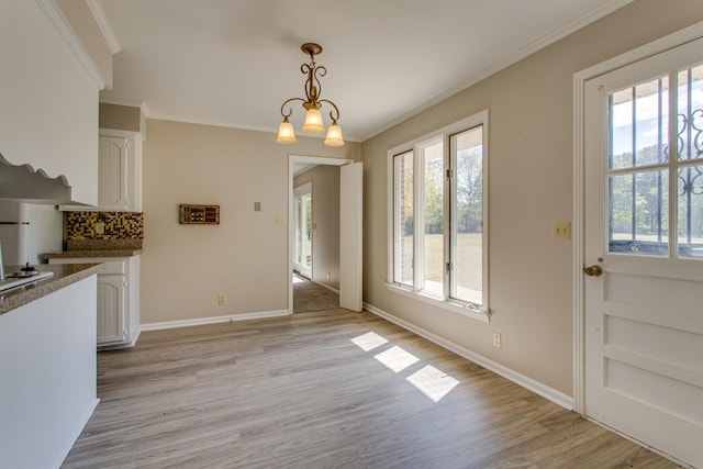 dining area with ornamental molding, light wood-type flooring, and a wealth of natural light