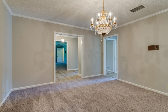 carpeted spare room featuring ornamental molding, a notable chandelier, and a textured ceiling