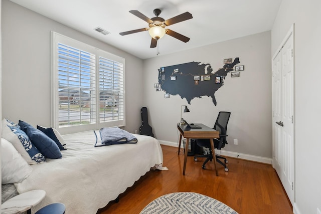 bedroom featuring ceiling fan, dark wood-type flooring, and a closet