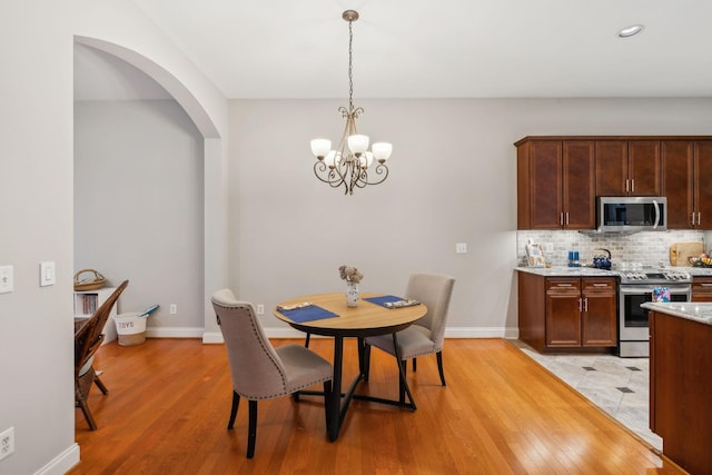 dining room with light wood-type flooring and a chandelier