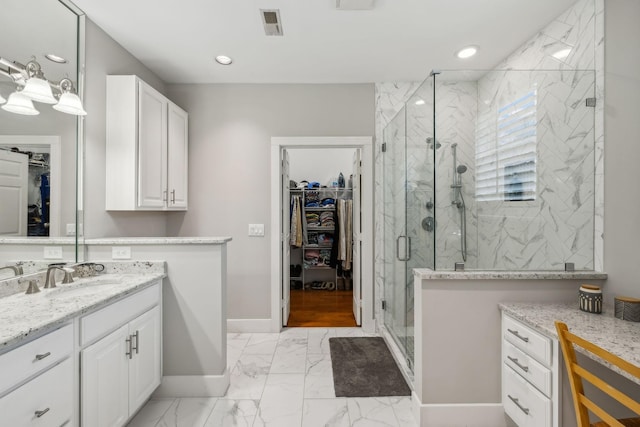 bathroom with vanity and a shower with door