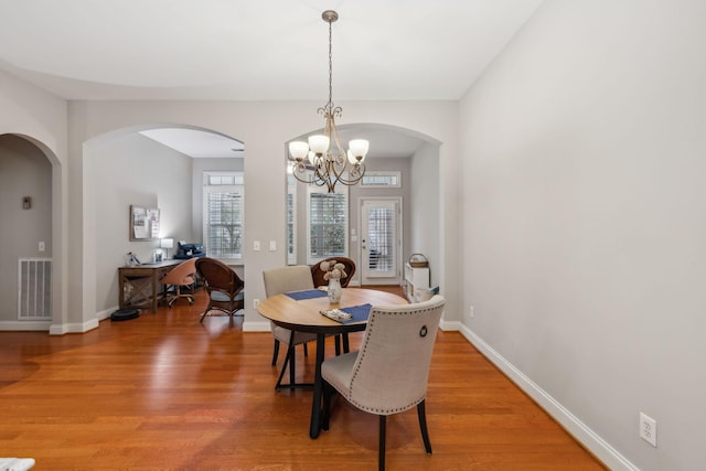 dining room featuring wood-type flooring and a notable chandelier