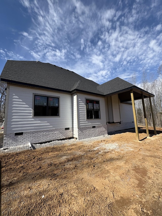 back of house featuring a shingled roof and crawl space