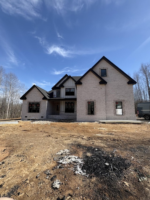 back of property with board and batten siding and brick siding