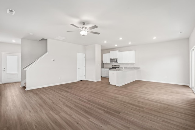 unfurnished living room with wood-type flooring and ceiling fan