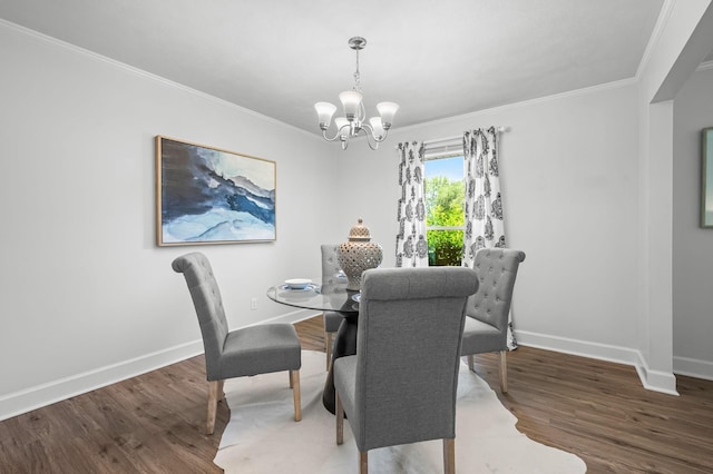 dining space featuring dark wood-type flooring, a chandelier, and ornamental molding