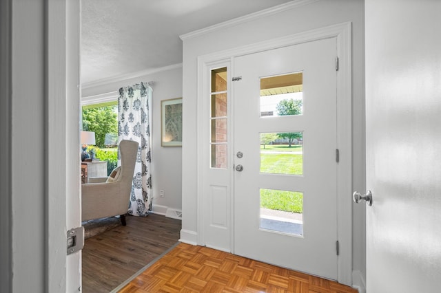 entrance foyer with a textured ceiling, light parquet flooring, plenty of natural light, and ornamental molding