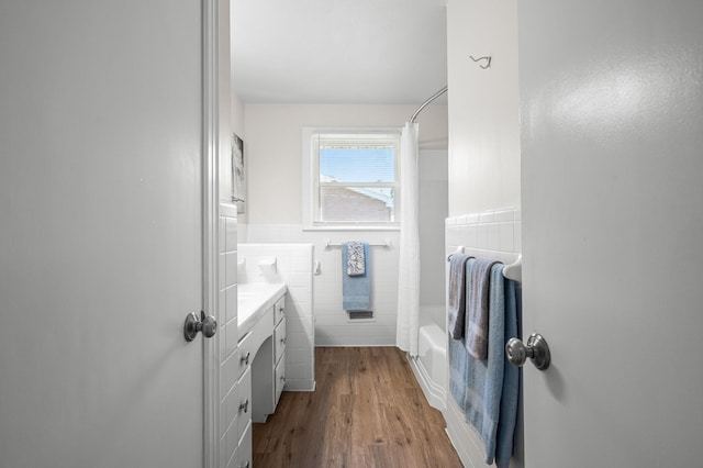 bathroom with vanity, shower / bathtub combination with curtain, tile walls, and hardwood / wood-style flooring