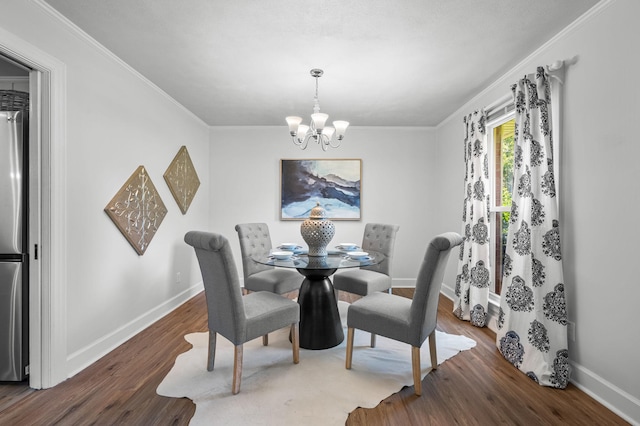 dining room featuring dark hardwood / wood-style flooring, ornamental molding, and an inviting chandelier