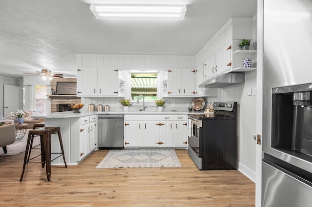 kitchen featuring sink, white cabinetry, a breakfast bar area, and appliances with stainless steel finishes