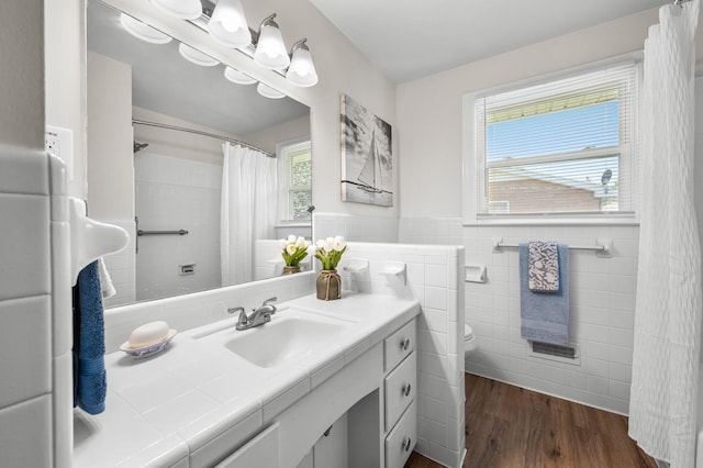 bathroom with hardwood / wood-style floors, vanity, toilet, tile walls, and a wealth of natural light