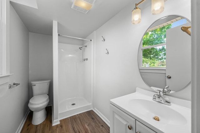 bathroom featuring vanity, toilet, wood-type flooring, and walk in shower