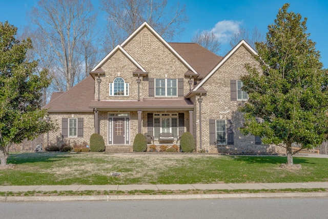 view of front of home with a porch and a front yard