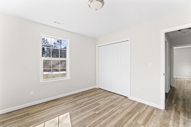 unfurnished bedroom with a closet and light wood-type flooring