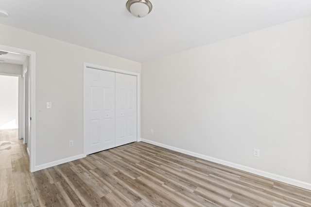 unfurnished bedroom featuring wood-type flooring and a closet