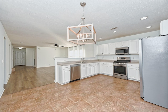 kitchen featuring pendant lighting, ceiling fan, white cabinetry, and appliances with stainless steel finishes