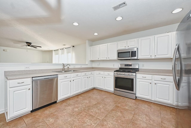 kitchen featuring white cabinetry, sink, ceiling fan, a textured ceiling, and appliances with stainless steel finishes