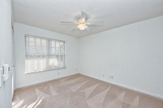 carpeted empty room featuring ceiling fan and a textured ceiling