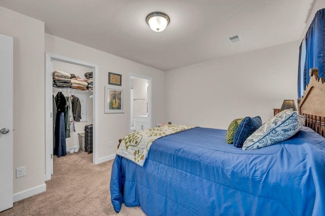 carpeted bedroom featuring a walk in closet, connected bathroom, and a closet