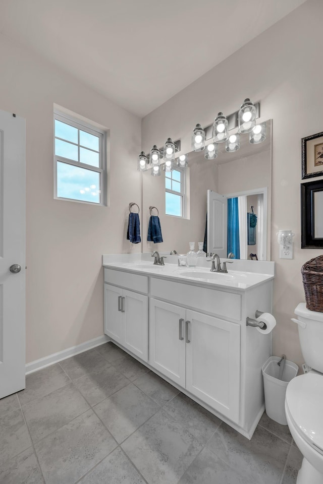 bathroom featuring a wealth of natural light, tile patterned flooring, vanity, and toilet