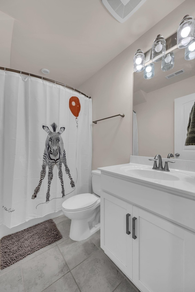 bathroom with a shower with curtain, vanity, toilet, and tile patterned floors