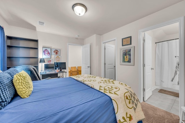 bedroom featuring connected bathroom and light colored carpet