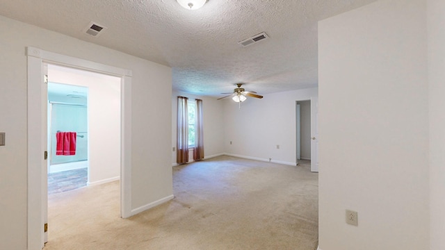 empty room with light carpet, a textured ceiling, and ceiling fan