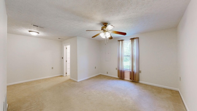 carpeted empty room with ceiling fan and a textured ceiling