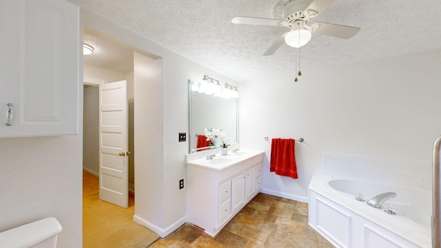 bathroom with a textured ceiling, vanity, ceiling fan, and a bathing tub