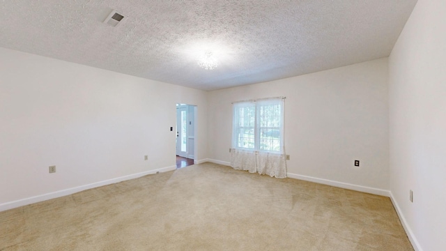 carpeted empty room with a textured ceiling