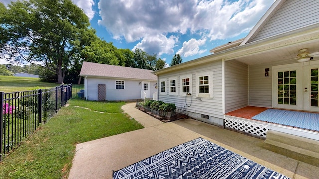 back of property featuring a lawn, a patio area, and ceiling fan