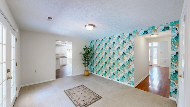 carpeted spare room featuring a textured ceiling