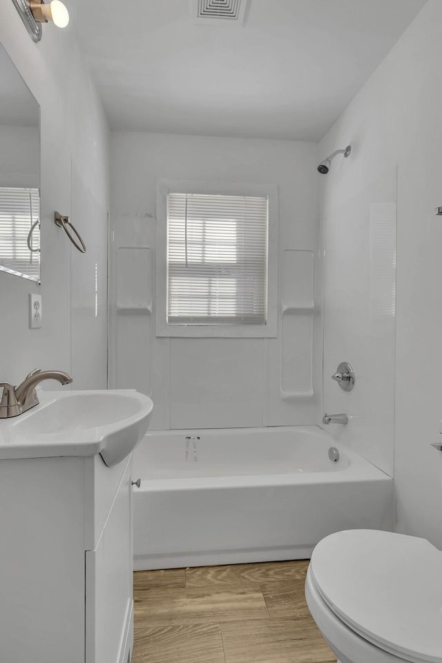 full bathroom with shower / bathing tub combination, vanity, toilet, and plenty of natural light