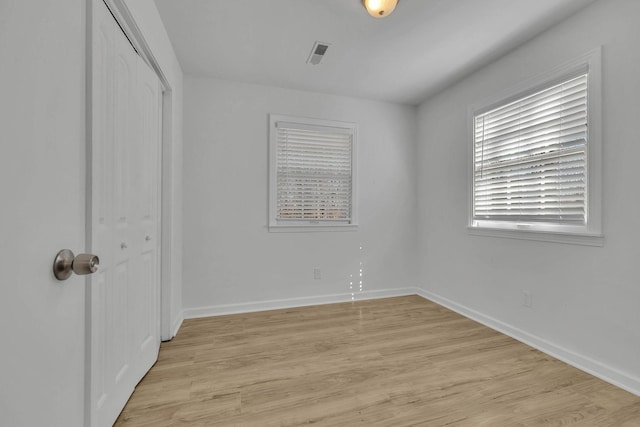 unfurnished bedroom with a closet and light hardwood / wood-style floors