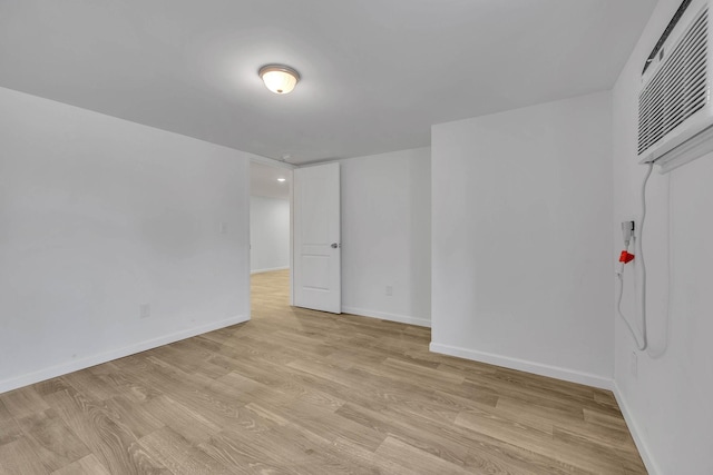 empty room featuring light hardwood / wood-style flooring and a wall mounted air conditioner