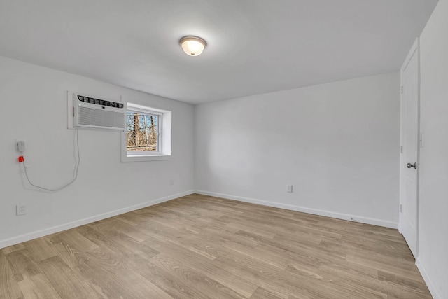 unfurnished room featuring a wall mounted air conditioner and light wood-type flooring