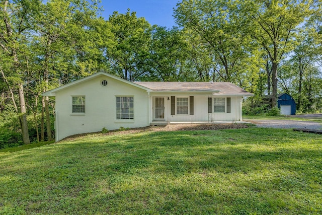 ranch-style house featuring a front lawn, covered porch, and a garage