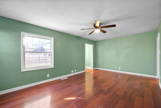 unfurnished room with a textured ceiling, ceiling fan, and dark hardwood / wood-style floors