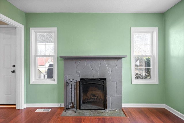 room details with hardwood / wood-style floors and a stone fireplace