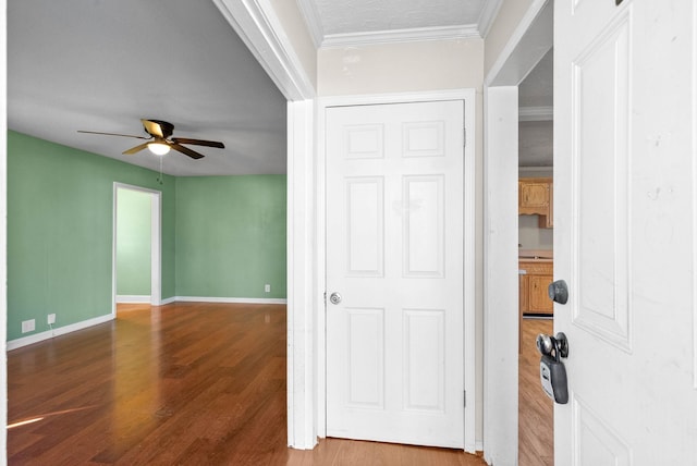 interior space with a textured ceiling, crown molding, and wood-type flooring