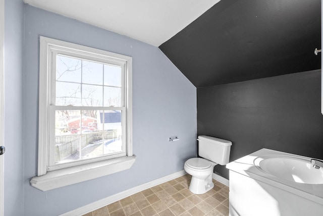 bathroom featuring toilet, vanity, and lofted ceiling