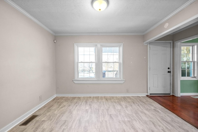 empty room with crown molding, a textured ceiling, and light hardwood / wood-style floors