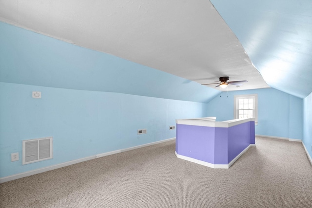 additional living space featuring ceiling fan, lofted ceiling, and light colored carpet