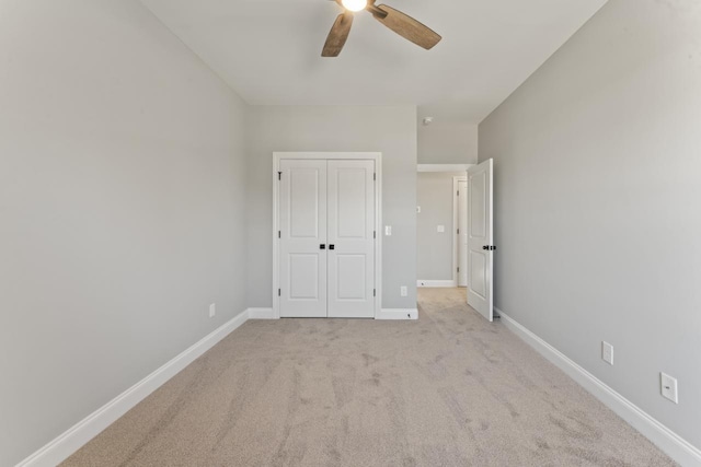 unfurnished bedroom with ceiling fan, a closet, and light colored carpet