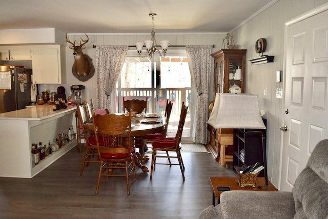 dining area with dark hardwood / wood-style flooring, a notable chandelier, and crown molding