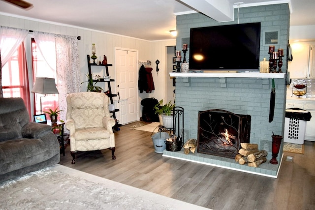 living room with crown molding, hardwood / wood-style flooring, and a fireplace