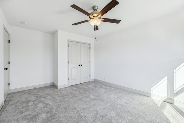 unfurnished bedroom with ceiling fan, light carpet, and a closet